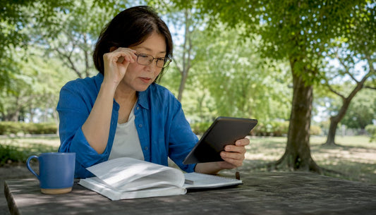 Woman comparing digital and print reading formats