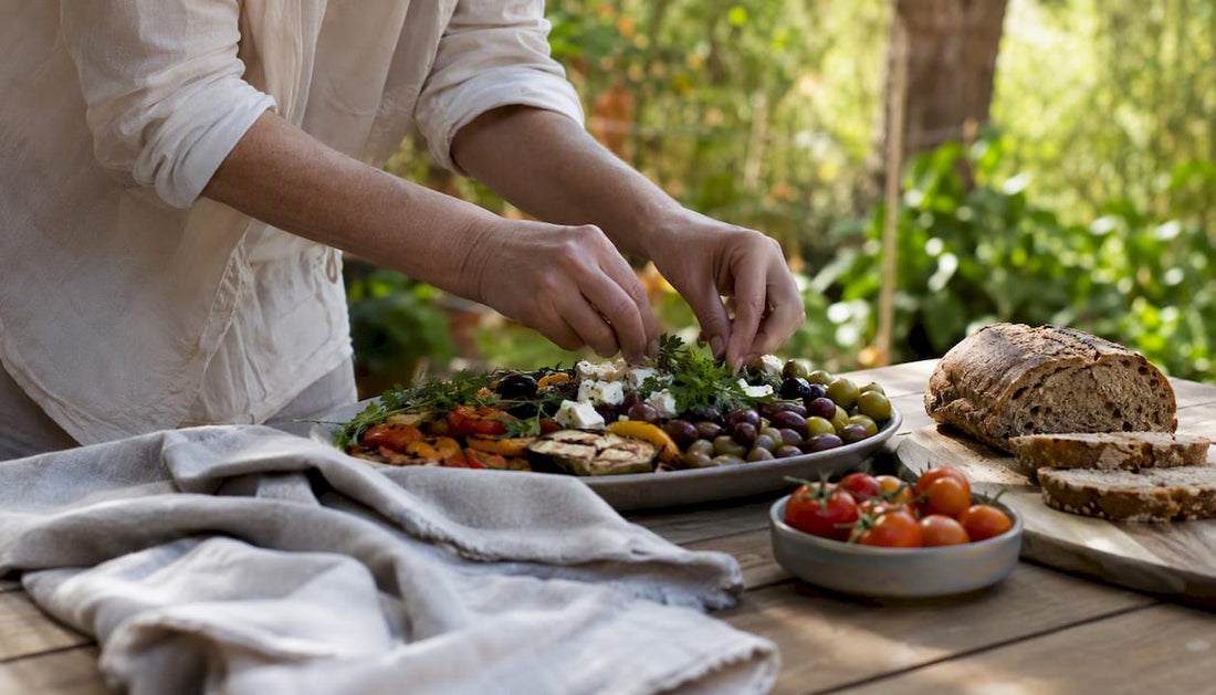 Hands drizzling olive oil over Mediterranean salad